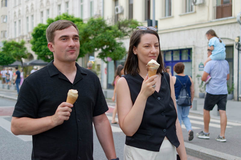 1 - Couple walking together in a city while eating ice cream cones